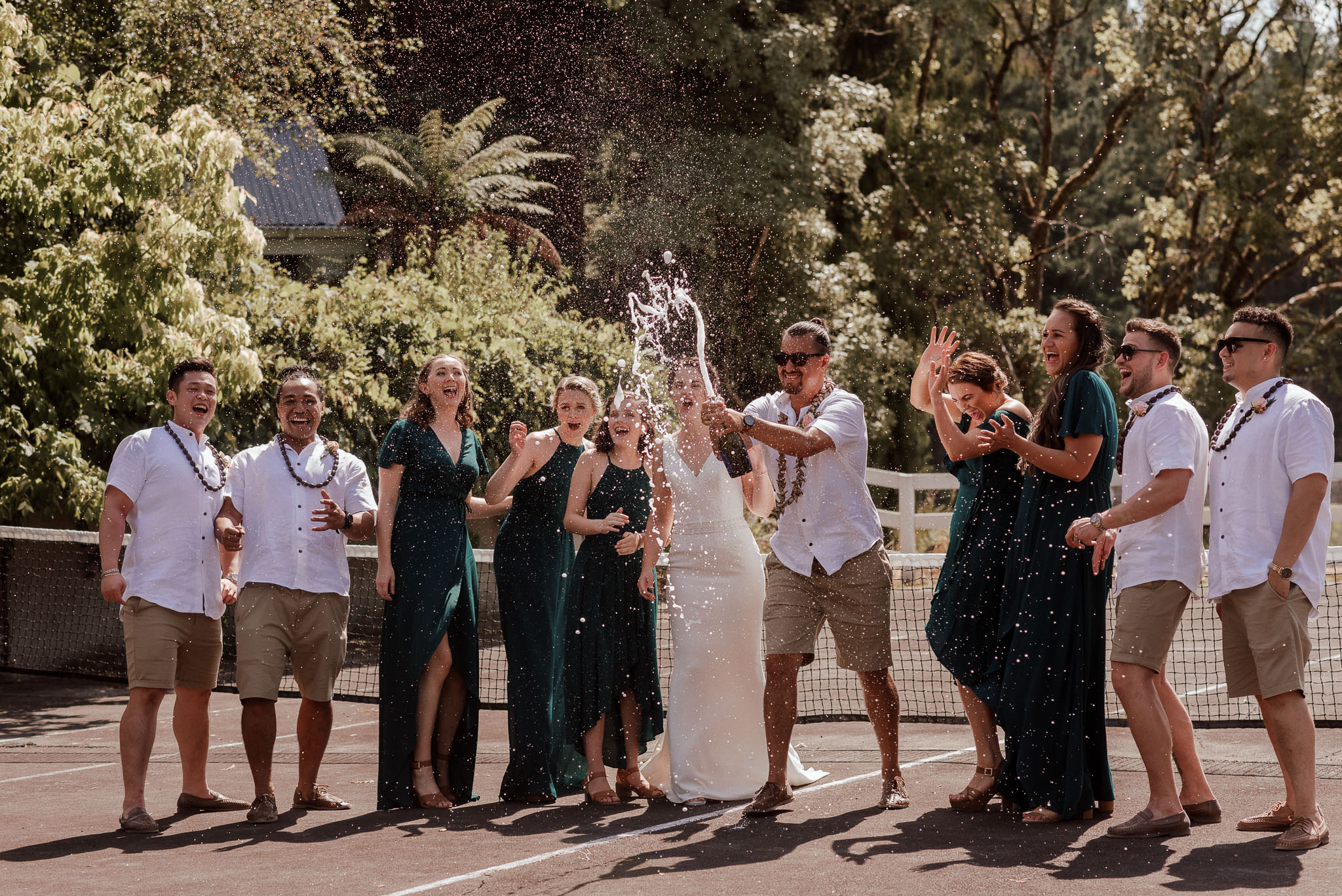 Bride and groom and wedding party opening champagne during destination wedding