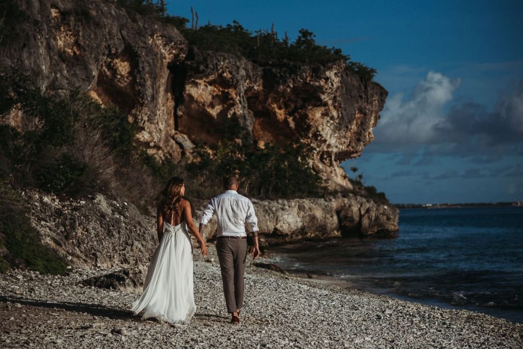 bruidspaar loopt weg langs het strand op bonaire