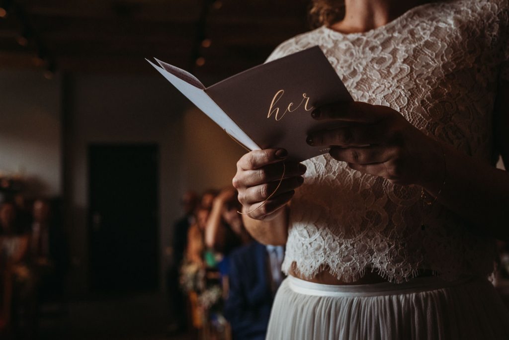 geloftenboekje tijdens ceremonie, de letters her lichten goud op