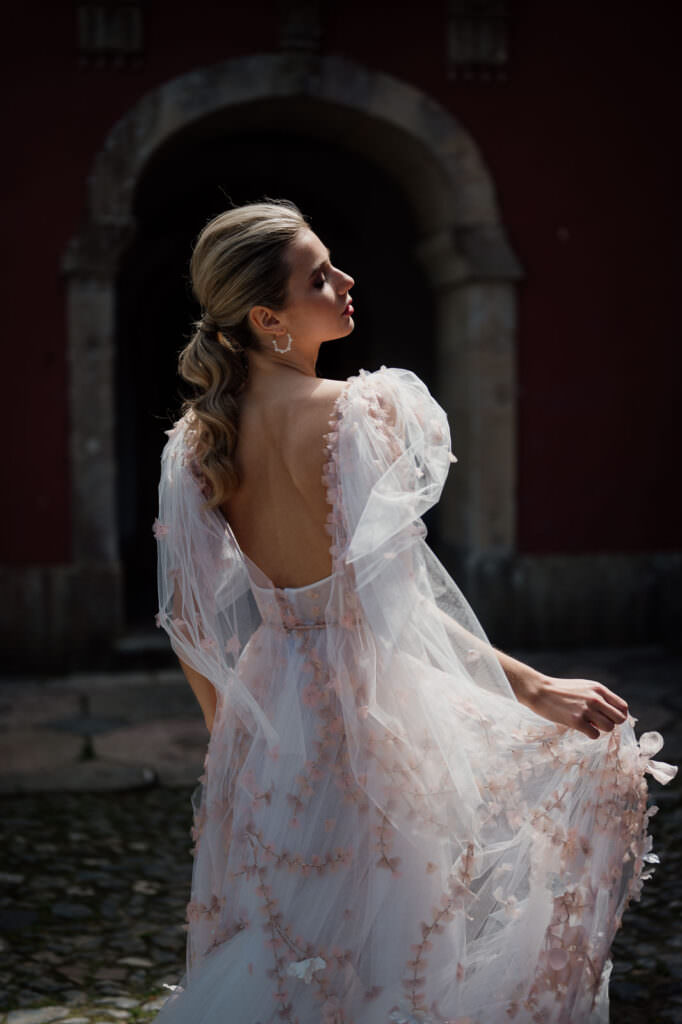 Wedding and Elopement photographer, bride smiling over her shoulder in a floral puff-sleeve gown