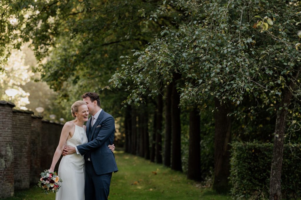 Candid and intimate moment shared between a bride and groom in the summer garden of an elegant wedding venue