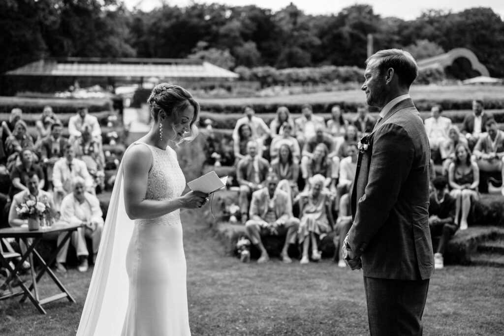 wedding photographer couple exchanging vows during outdoor ceremony