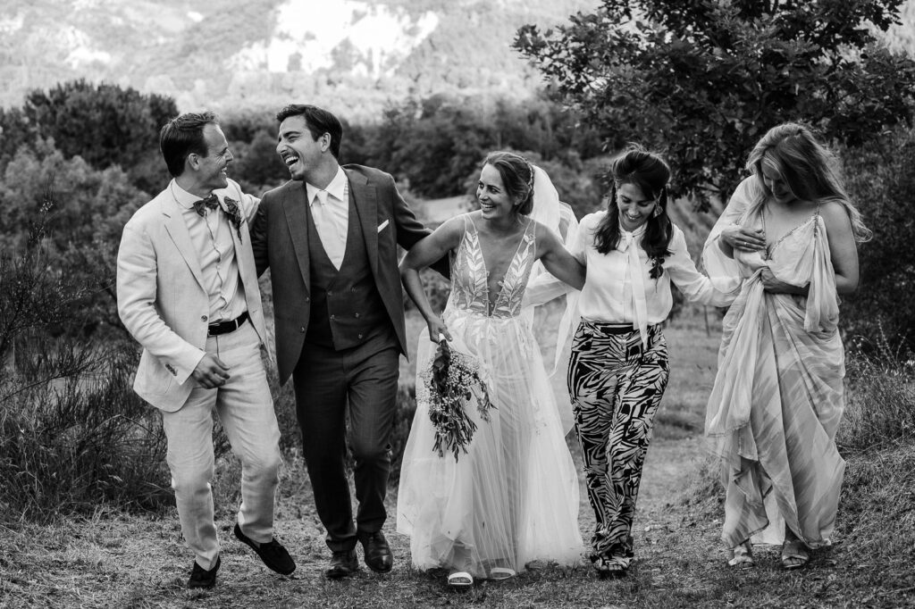 Wedding couple smiling and laughing with their loved ones at an outdoor wedding venue