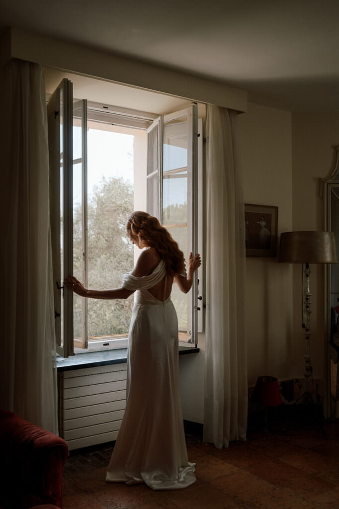 wedding photography bride standing at the window looking outside i France for destination wedding