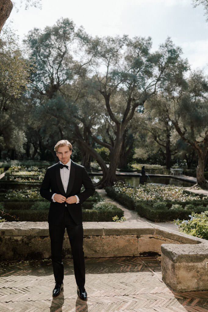 groom standing in garden waiting for his bride