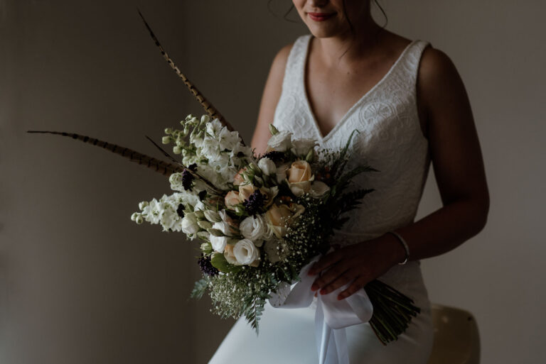 close up of bridal bouquet with feathers