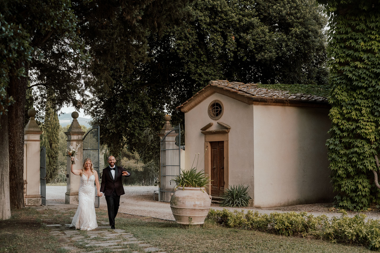 couple walking towards dinner setting in beautiful tuscan surroundings. Weddingphotographer