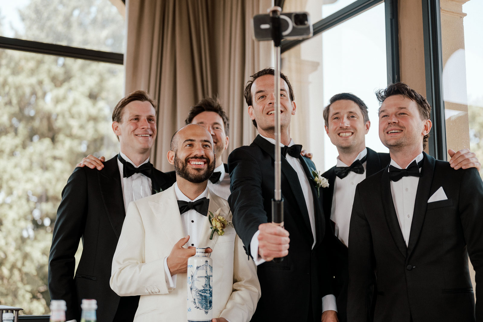 wedding photography services, groomsmen taking a selfie with the groom