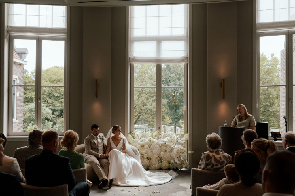 couple sitting on couch with beautiful florals in pillows amsterdam, wedding photography service